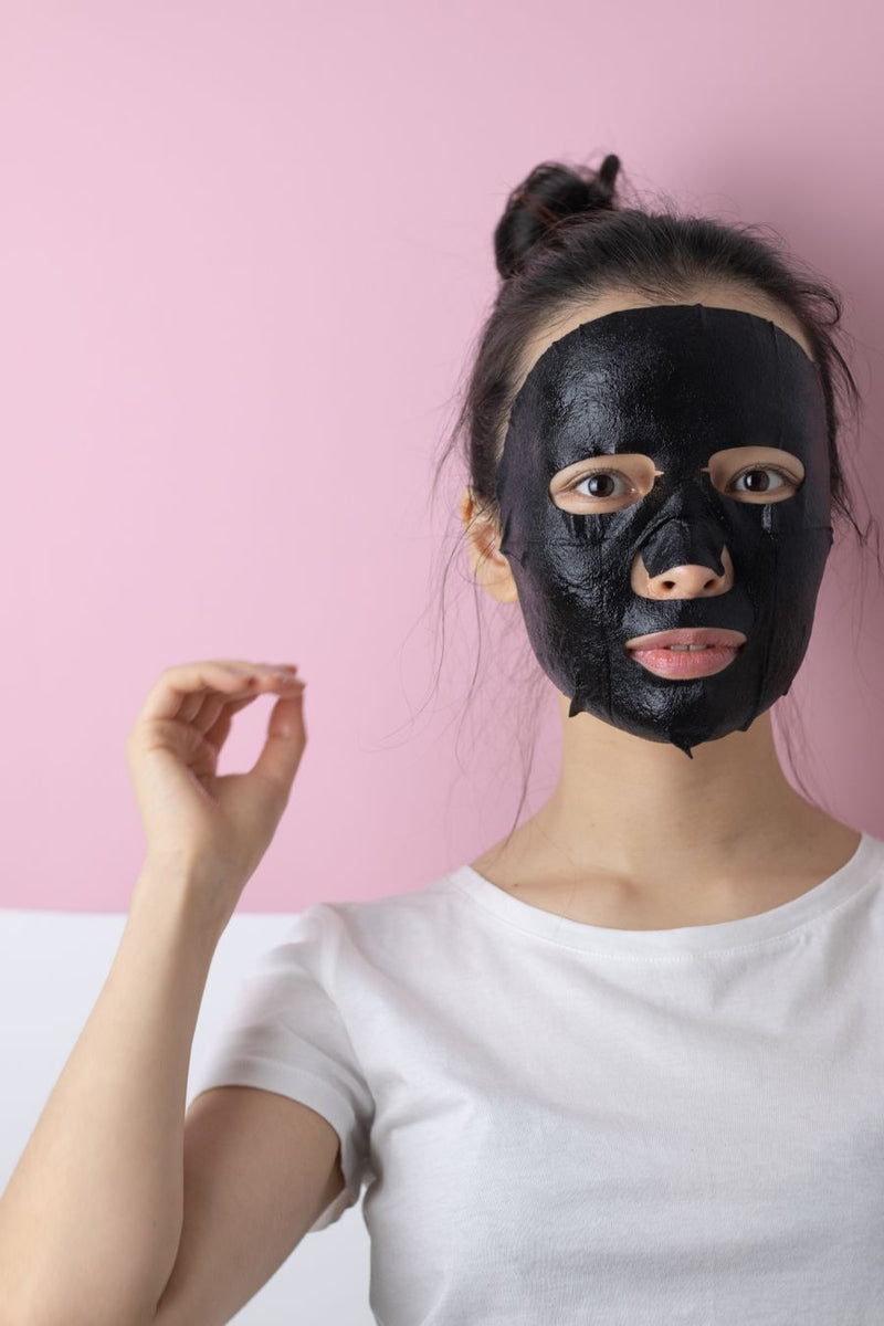 Activated charcoal skincare being massaged onto the face
