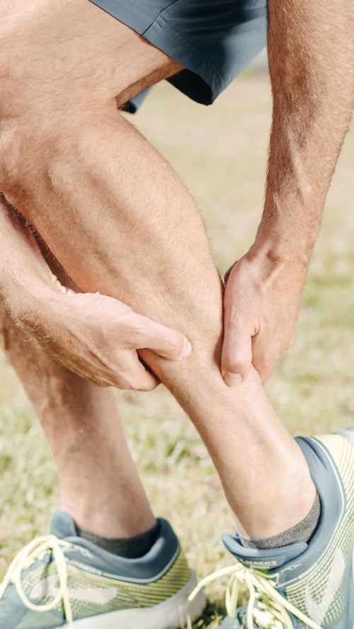 Man massaging his calf muscle after exercise
