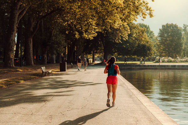Woman jogging outdoors in the sun, representing clean sustained energy